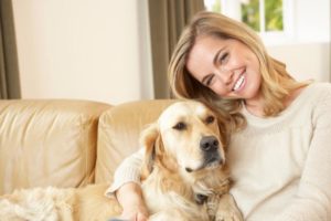 Frau mit altem Hund auf einem Sofa